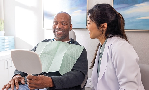 senior smiles with a medical professional, showing how United Concordia Dental supports healthy smiles.