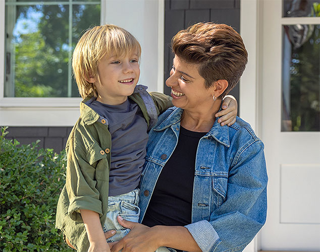 A smiling middle-aged adult hugs a child, showing how FEDVIP dental coverage supports family health.