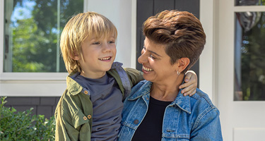 A smiling middle-aged adult hugs a child, showing how FEDVIP dental coverage supports family health.