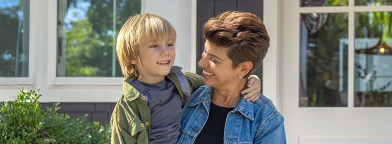 A smiling middle-aged adult hugs a child, showing how FEDVIP dental coverage supports family health.